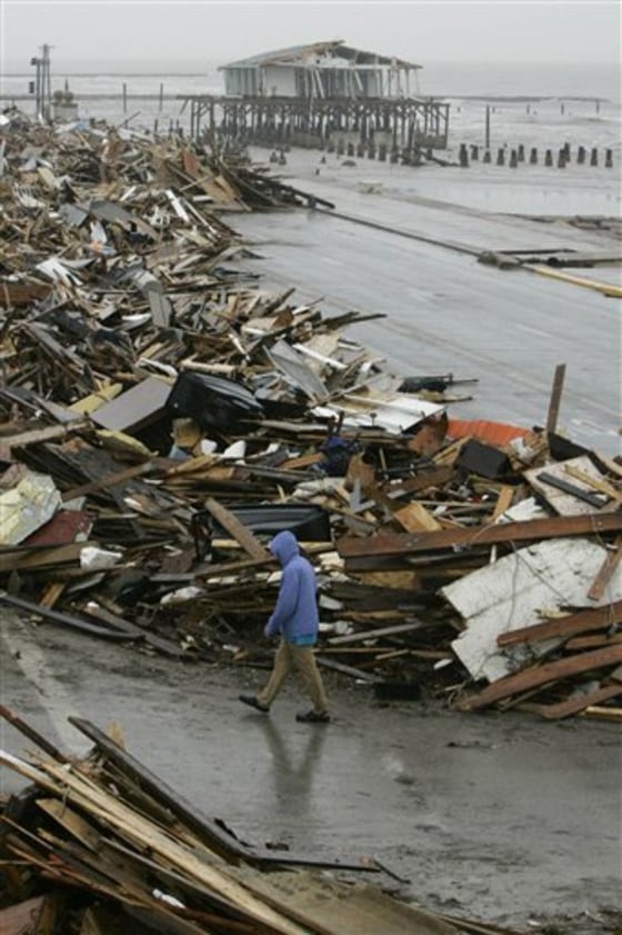 A man walks past debris piled up on the seawall road after Hurricane Ike hit the Texas coast, in Galveston, Texas, in this Sept. 14, 2008 file photo.